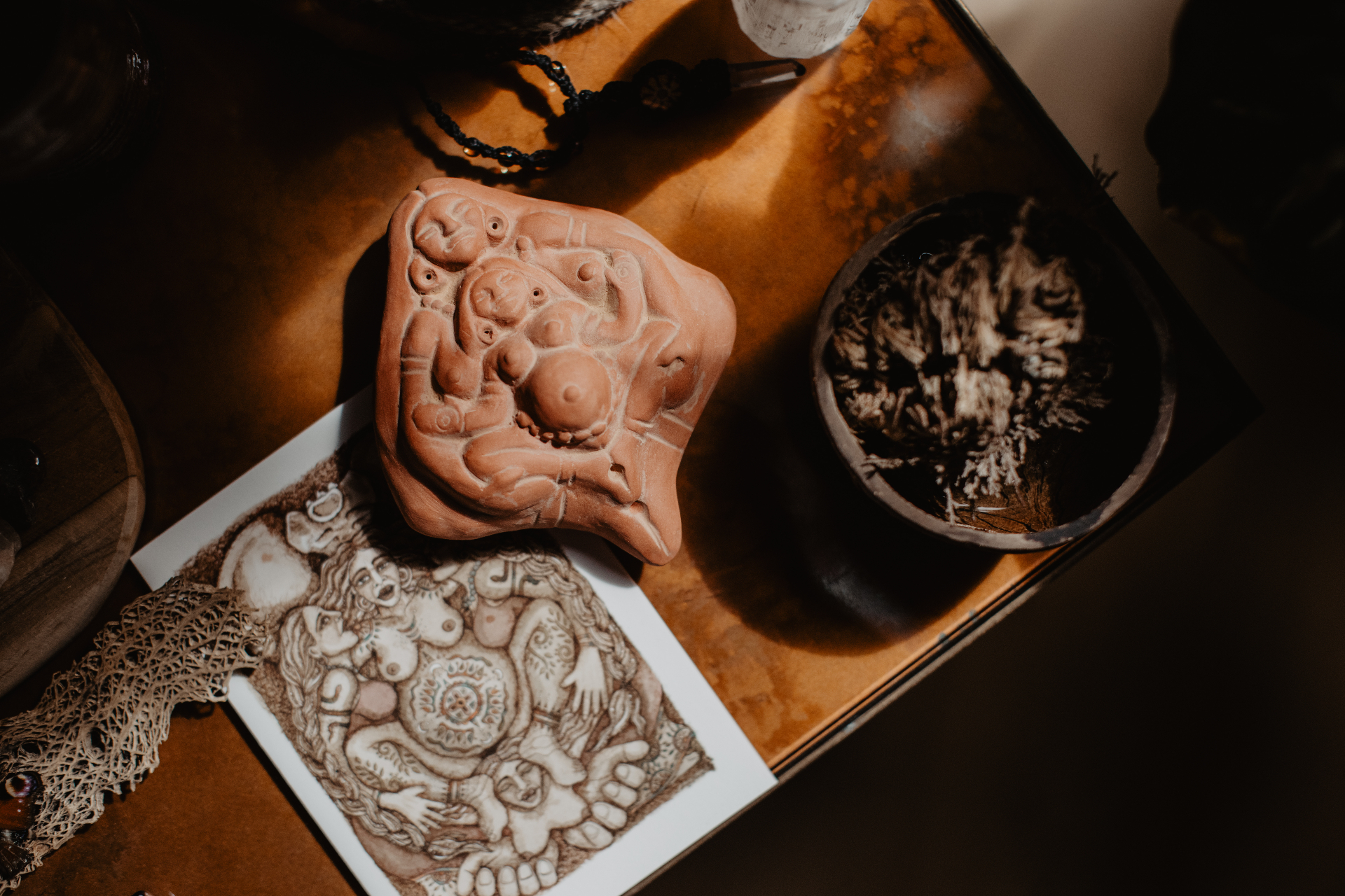 Terracotta beeldje van moeder en kind op een warm houten altaar — Sansura